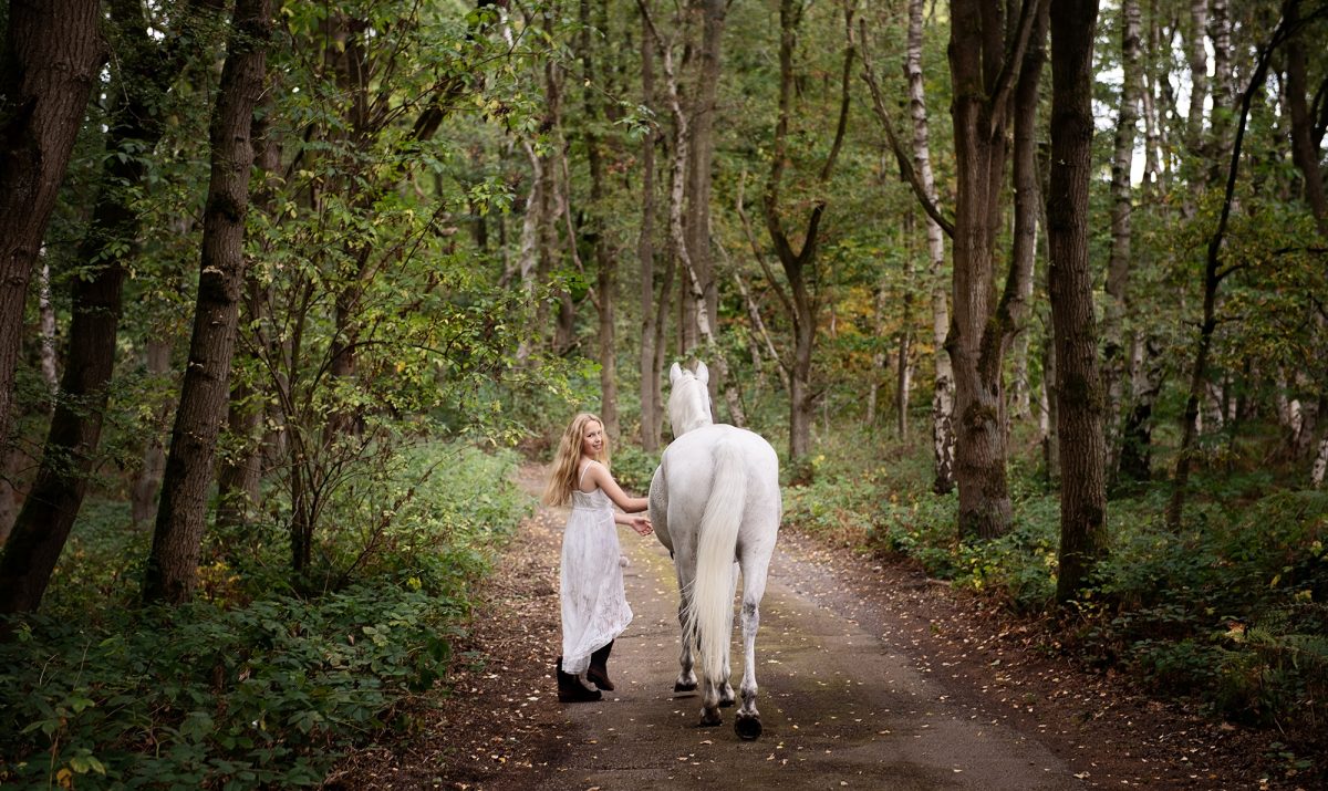 Young person with pony and horse during an equine portrait photoshoot in a country estate setting, by Emma Campbell